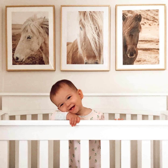 Emma Carter standing at her crib