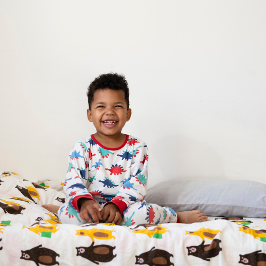 toddler smiling in his toddler bed