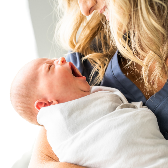 Laura Hunter holding a baby who is yawning