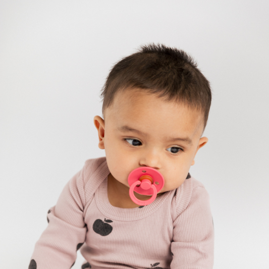 A baby with a bibs pacifier