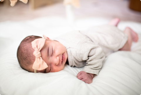 Baby peacefully sleeping with a bow headband