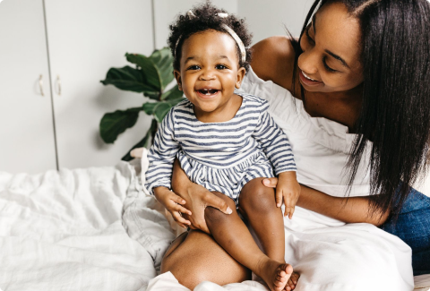 Mother holding smiling toddler girl