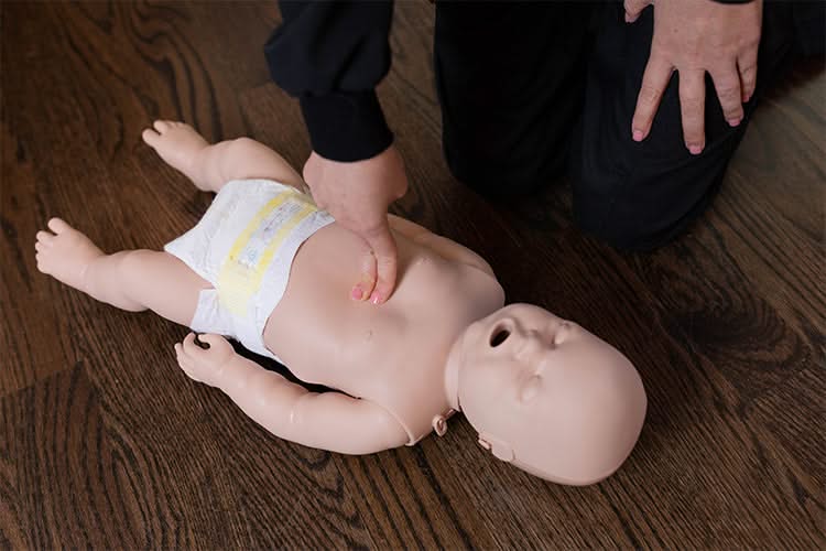 CPR and choking course shown on a baby doll