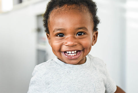Black toddler smiles for the camera