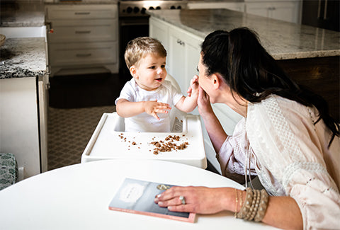 Mom and baby have a playful time during the baby's meal