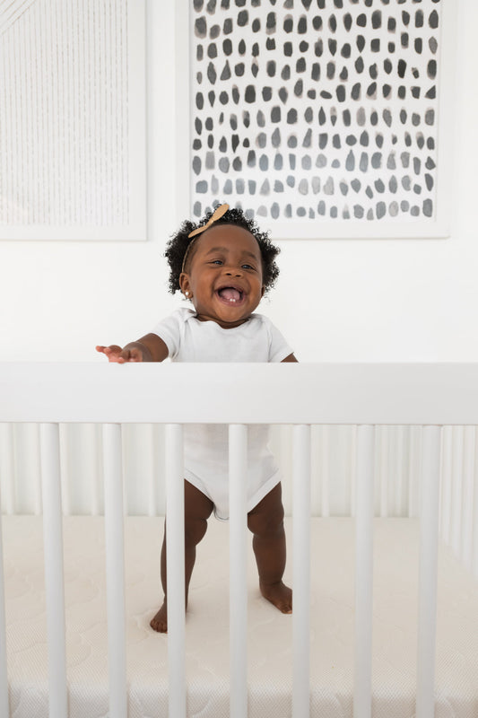 happy baby standing in crib
