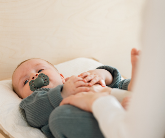 A baby with a bibs pacifier