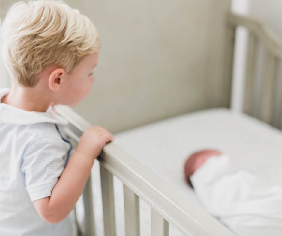 toddler looking at baby