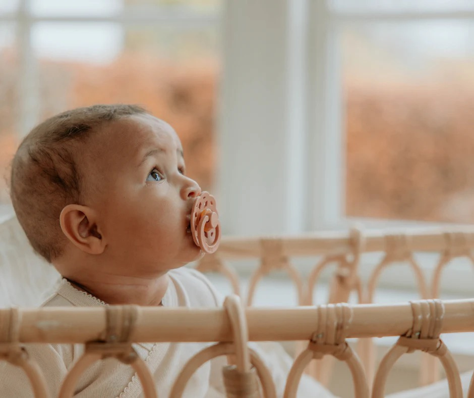 A baby with a bibs pacifier