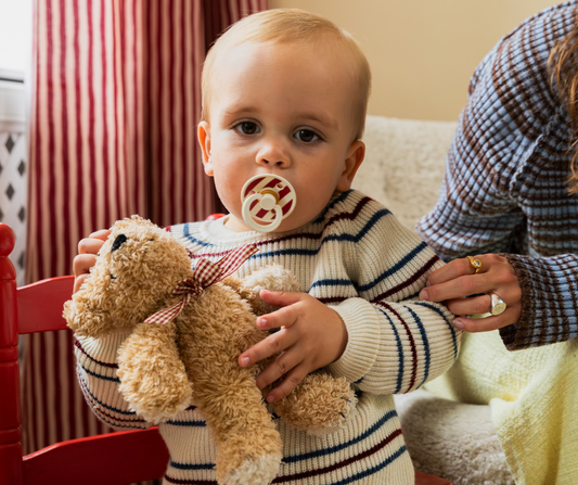 baby holding teddy bear