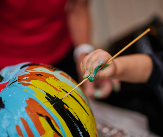 a kid painting a pumpkin