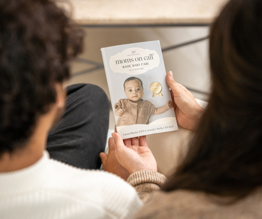 mom and dad holding 0-6 month book