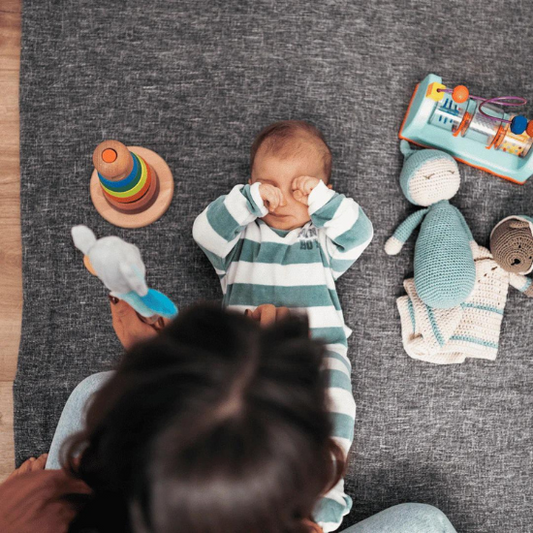 Baby wiping their eyes on the ground