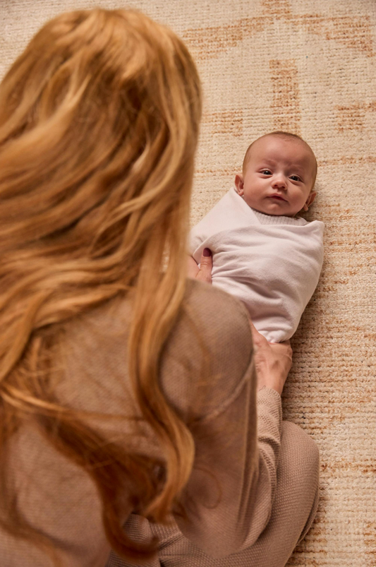 Mother holding her baby in a sleep sack