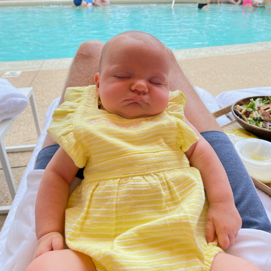 Baby sleeping with pool in background