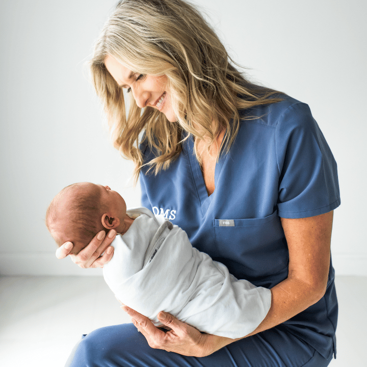 Blonde nurse holding a newborn