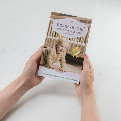 Book titled 'Moms on Call: Next Steps Baby Care' held by a person on a light background