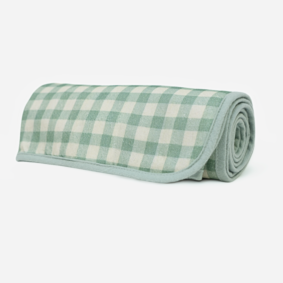 Rolled-up green and white checkered swaddle blanket on a white background