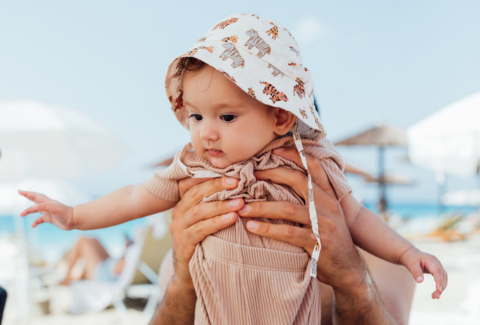 Dad holding baby at beach