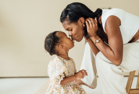 Mom kissing daughter