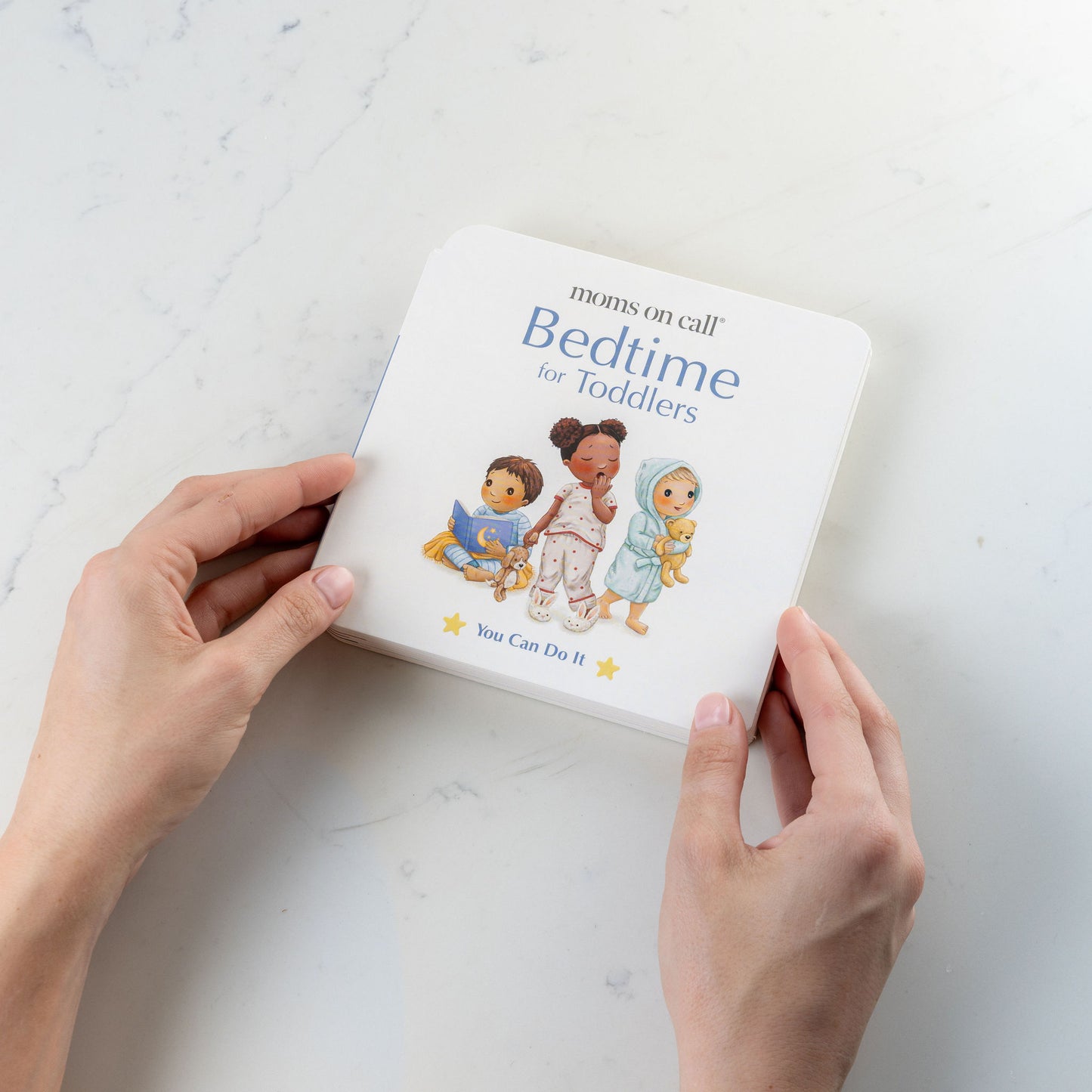 Book titled 'Bedtime for Toddlers' held by a person on a light background