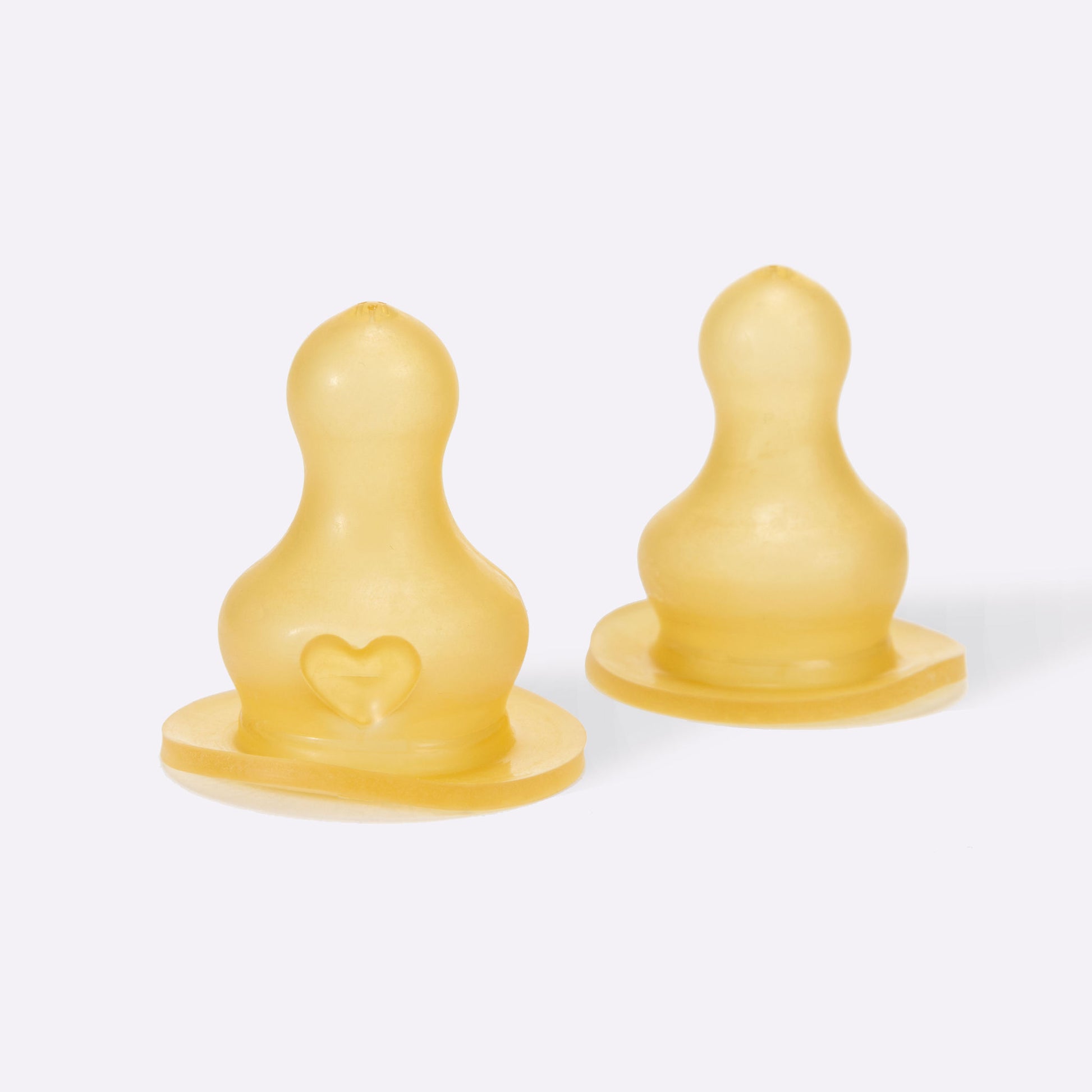 Two yellow baby pacifiers on a white background