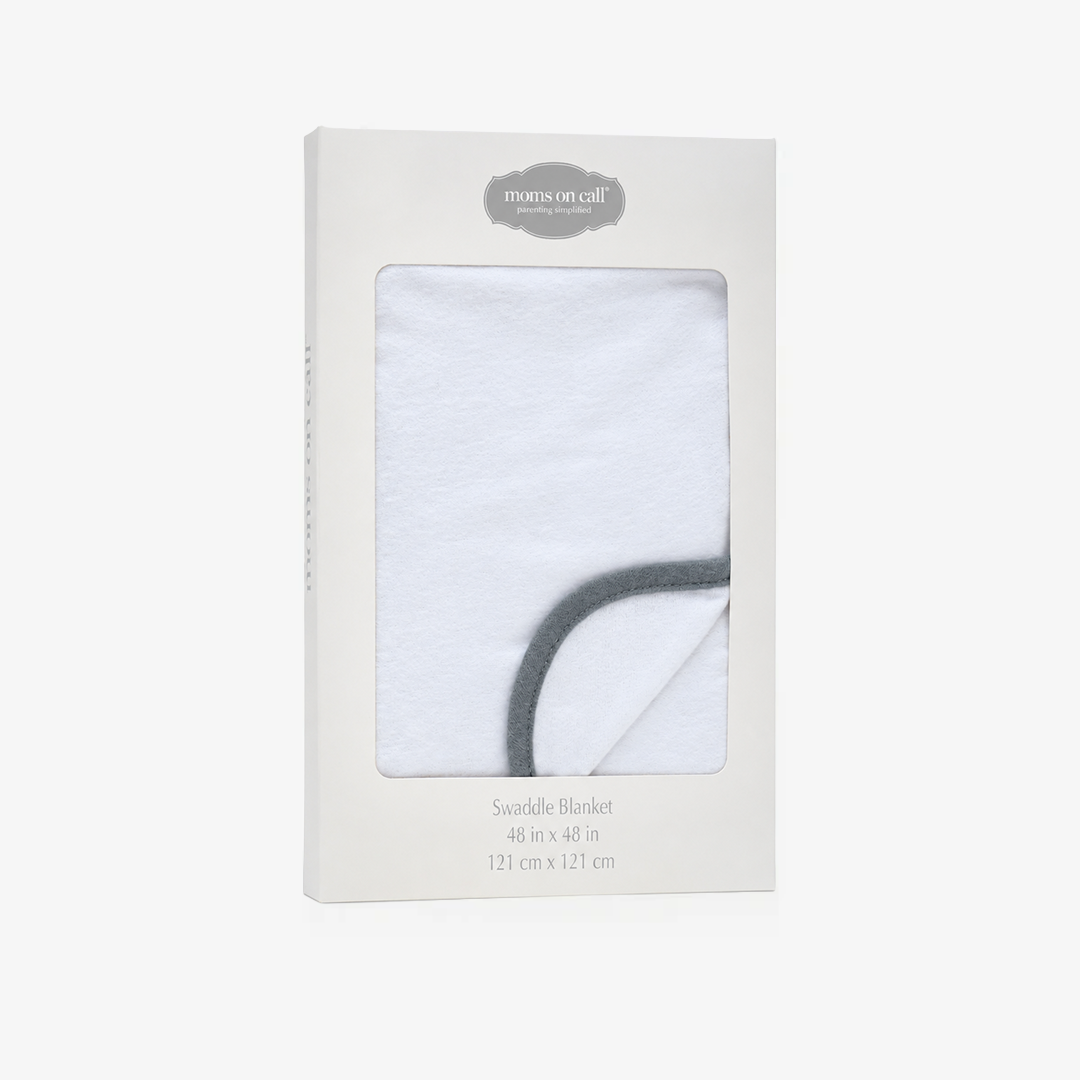 A packaged white swaddle blanket with a dark gray curved border, shown in its original white cardboard box with a clear window. The brand 'moms on call' is visible at the top of the packaging.
