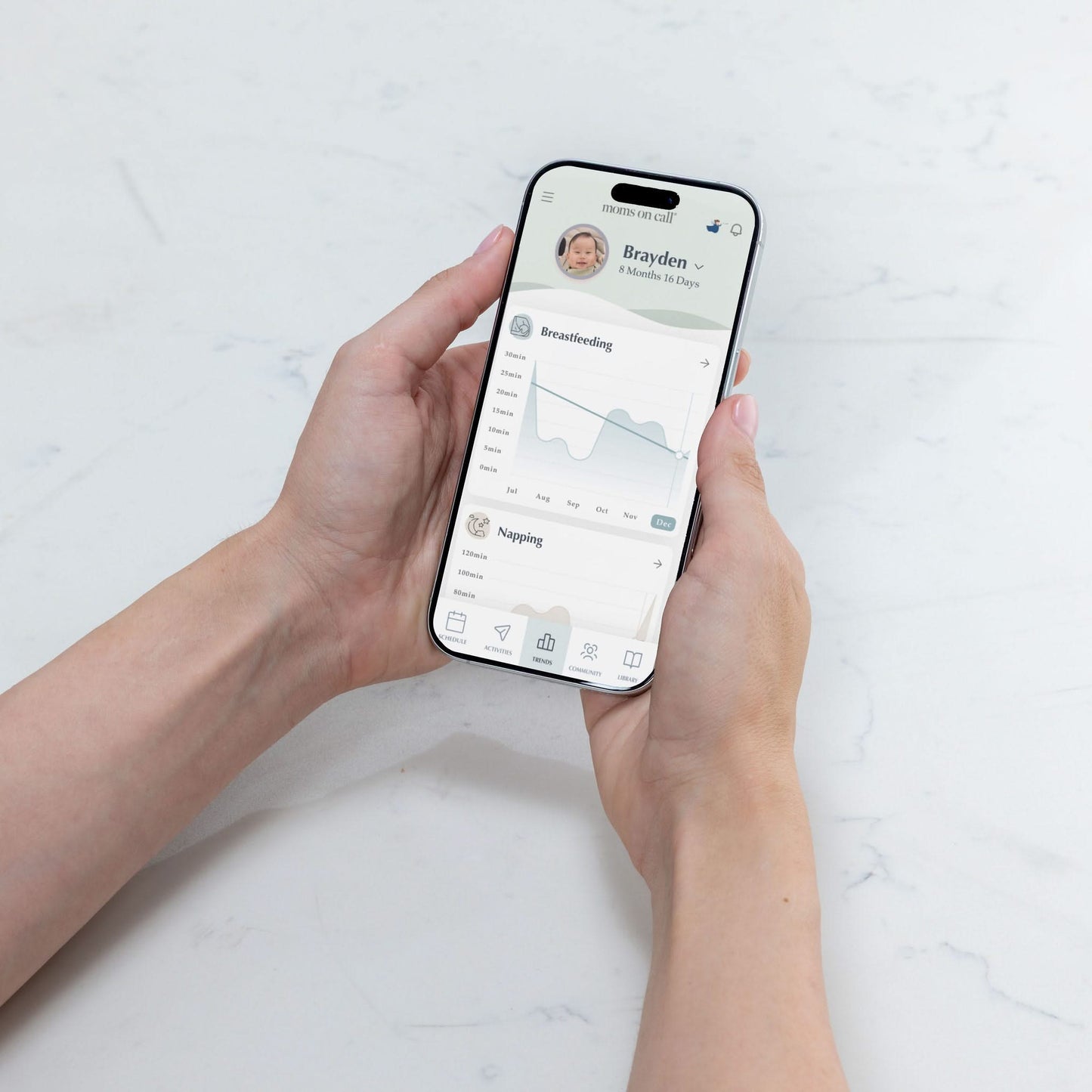Person holding a smartphone with The Moms on Call App