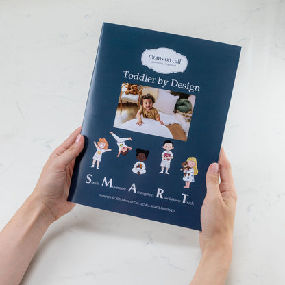 Book titled 'Toddler by Design' held by a person on a light background